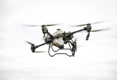 A drone capturing high-resolution aerial data for land surveying and mapping in a commercial setting.