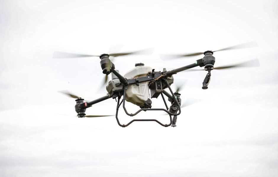 A drone capturing high-resolution aerial data for land surveying and mapping in a commercial setting.